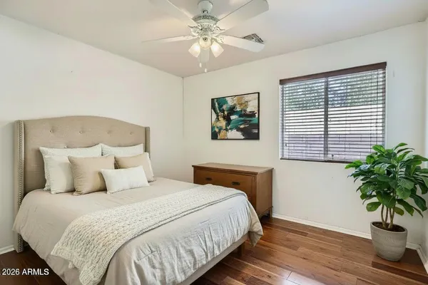 a bedroom with a large bed and a potted plant