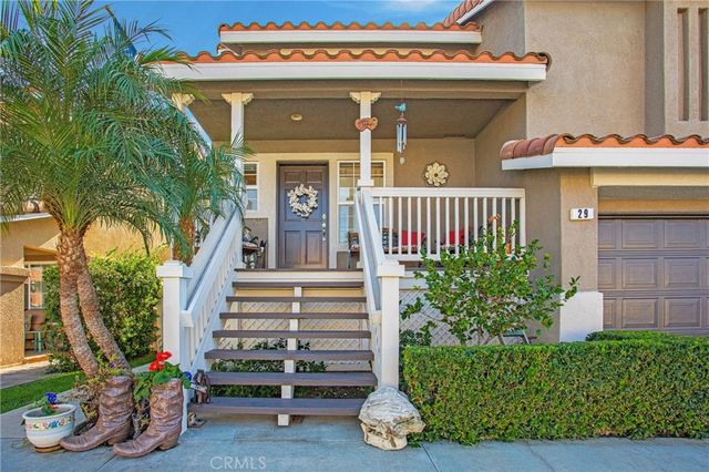 a view of a house with large windows and flower plants