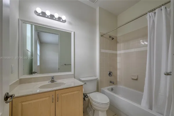 a bathroom with a granite countertop sink shower mirror and toilet