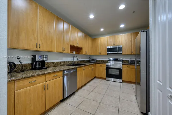 a kitchen with stainless steel appliances granite countertop a stove sink and cabinets