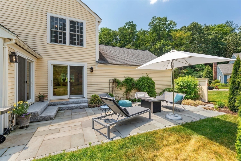 19 Edmonds Road Concord, MA 01742 - Photo 22 of 24 a view of a patio with couches table and chairs under an umbrella