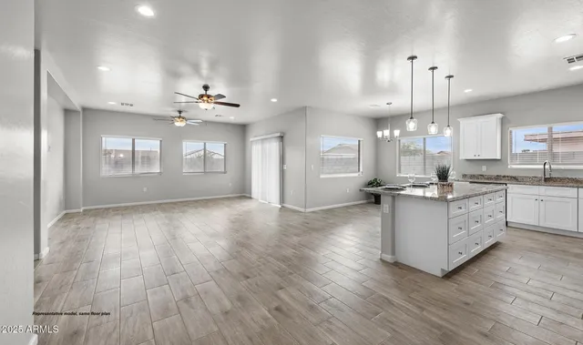 a large kitchen with stainless steel appliances granite countertop a lot of counter space and wooden floors