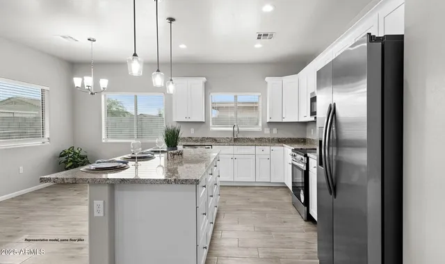 a kitchen with stainless steel appliances granite countertop a refrigerator a sink a stove and oven