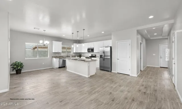 a view of kitchen with kitchen island white cabinets and refrigerator