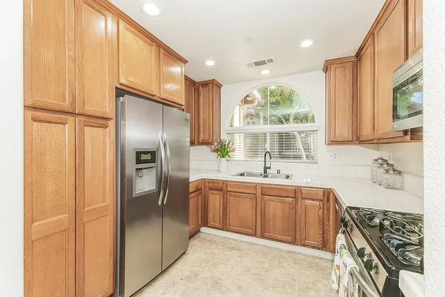 a kitchen with stainless steel appliances granite countertop a sink stove and refrigerator