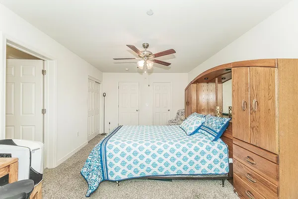 a bedroom with a large bed and a ceiling fan