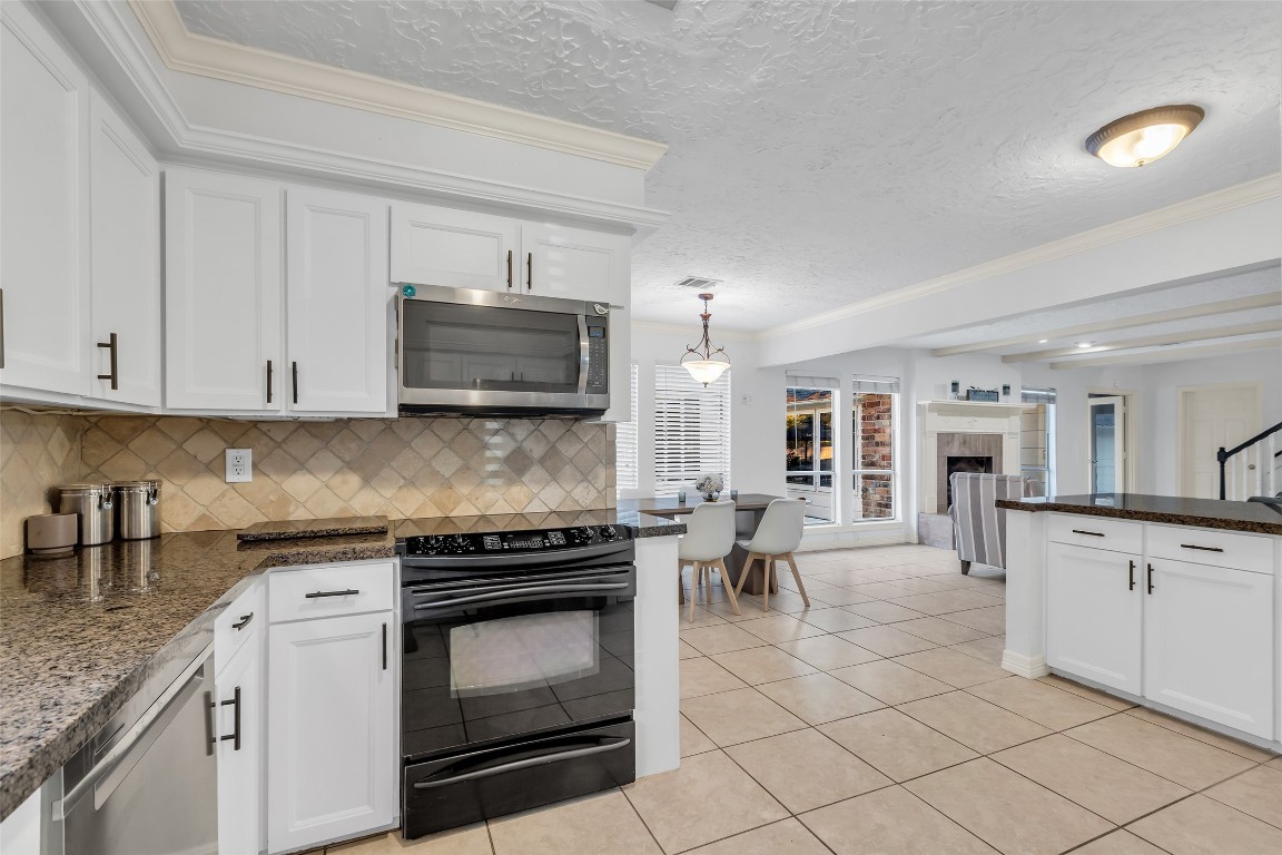 24102 Northcrest Drive Spring, TX 77389 - Photo 8 of 30 a kitchen with granite countertop a stove top oven and cabinets