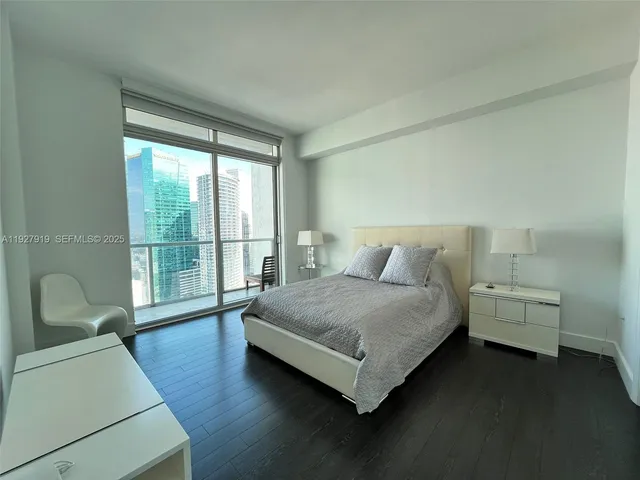 a spacious bedroom with a bed and a large window