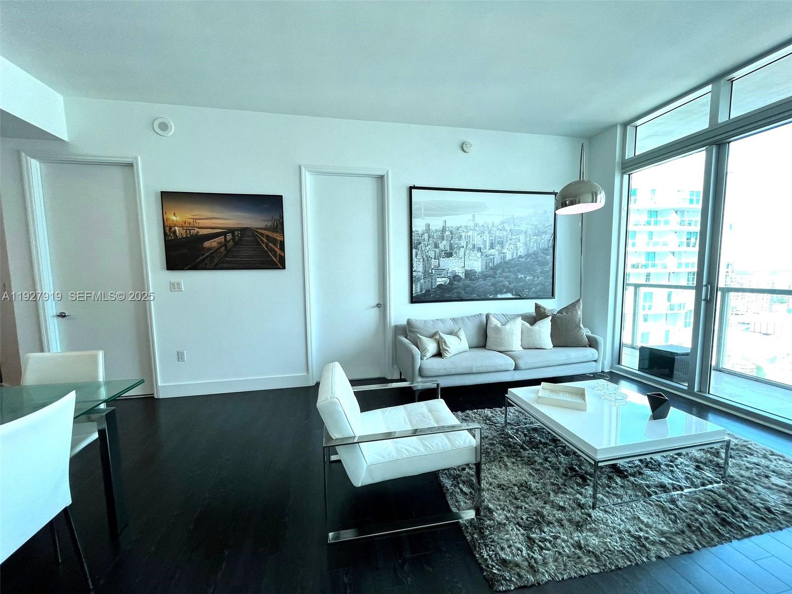 55 Southeast 6th Street, Unit 4103 Miami, FL 33131 - Photo 2 of 24 a living room with furniture and a flat screen tv