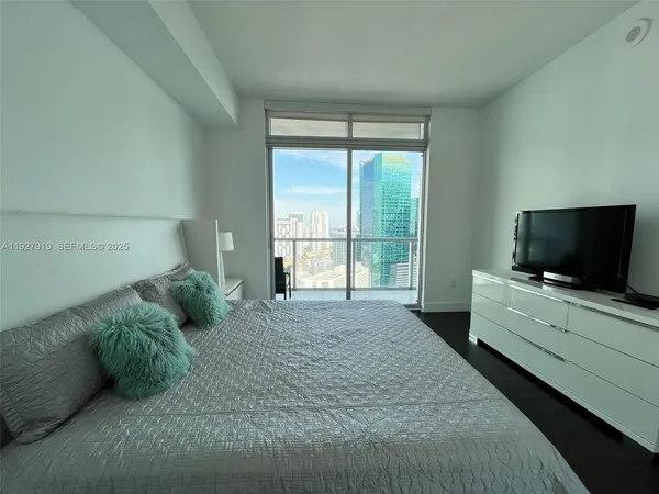 a bedroom with a bed and a flat screen tv