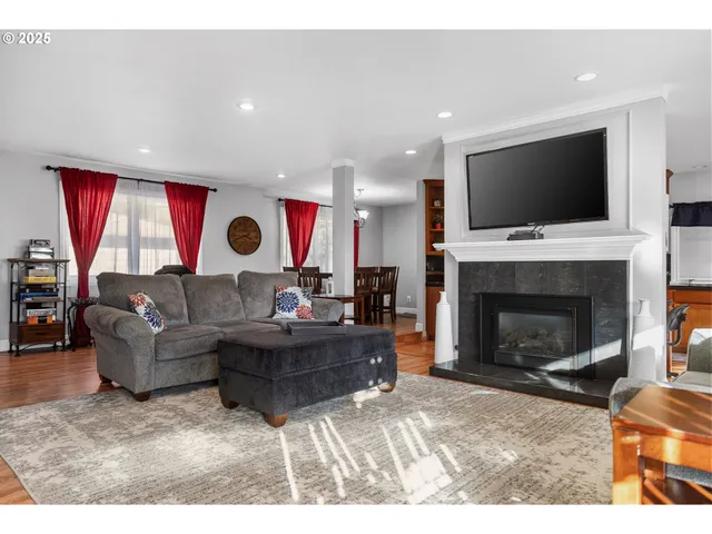 a living room with furniture a flat screen tv and a fireplace