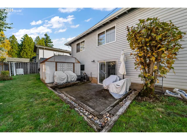 a view of a backyard with table and chairs and a barbeque
