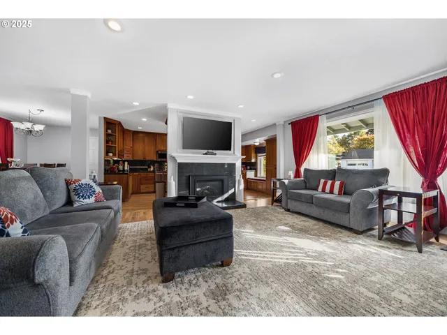 a living room with furniture a fireplace and a large window