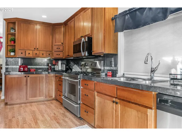 a kitchen with stainless steel appliances granite countertop a sink a stove and a microwave