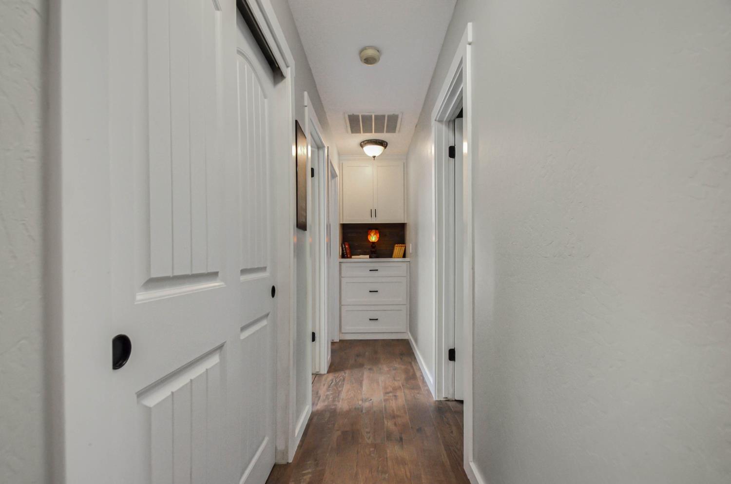 10376 Tabeaud Road Pine Grove, CA 95665 - Photo 40 of 70 hall way to primary bedroom, guest bedroom and guest bathroom, custom cabinet at the end (not as narrow as it looks)