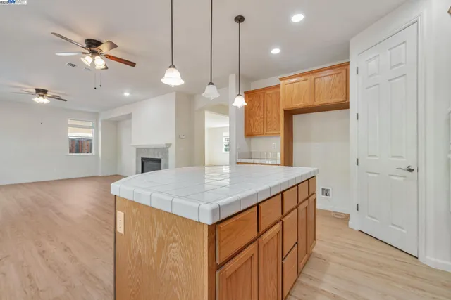 a kitchen with a sink chandelier and wooden floor