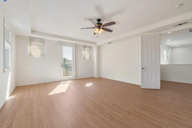 a view of a livingroom with wooden floor and a ceiling fan