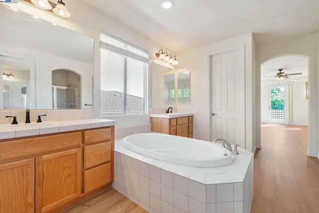 a bathroom with a tub a sink and mirror