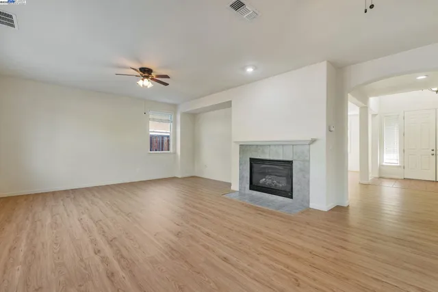 wooden floor fireplace and windows in an empty room