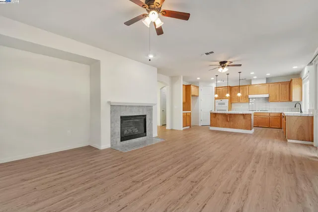 a view of a livingroom with a fireplace wooden floor and chandelier