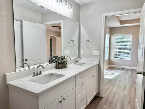 a view of a room with wooden floor and a ceiling fan