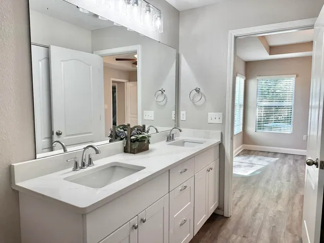 a view of a room with wooden floor and a ceiling fan