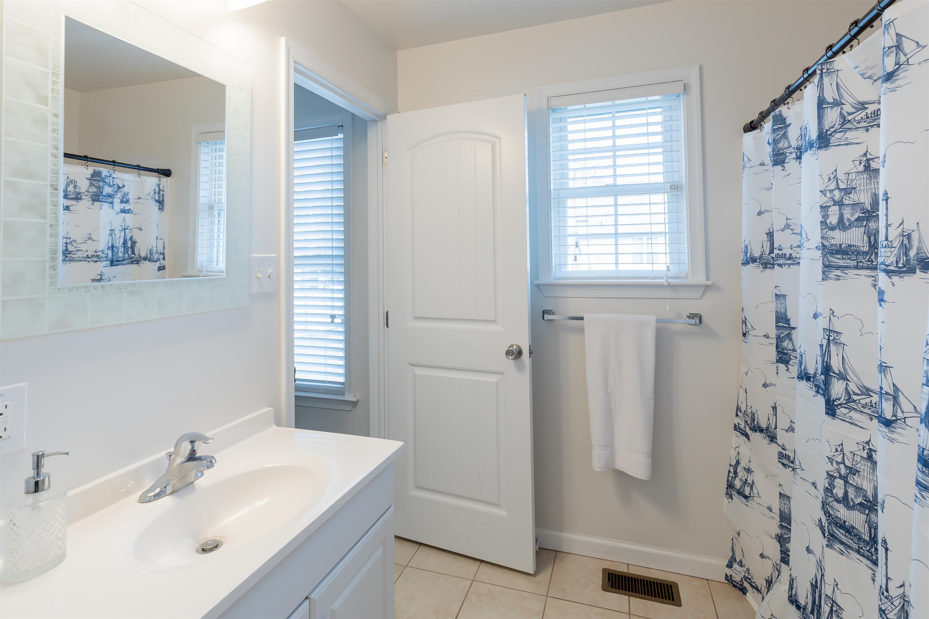 103 Avalon Road Cape May, NJ 08204 - Photo 18 of 33 a bathroom with a sink a mirror a window and a shower