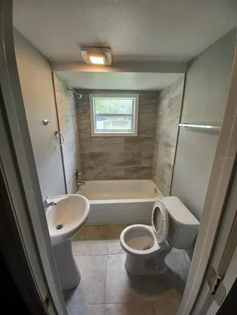 a bathroom with a toilet a sink and bathtub