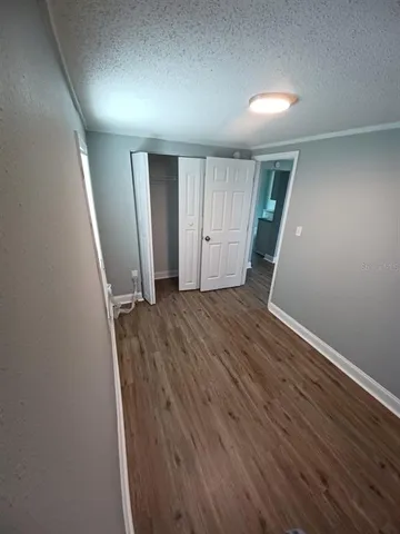 an empty room with wooden floor and closet