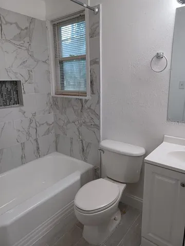 a white toilet sitting next to a bath tub