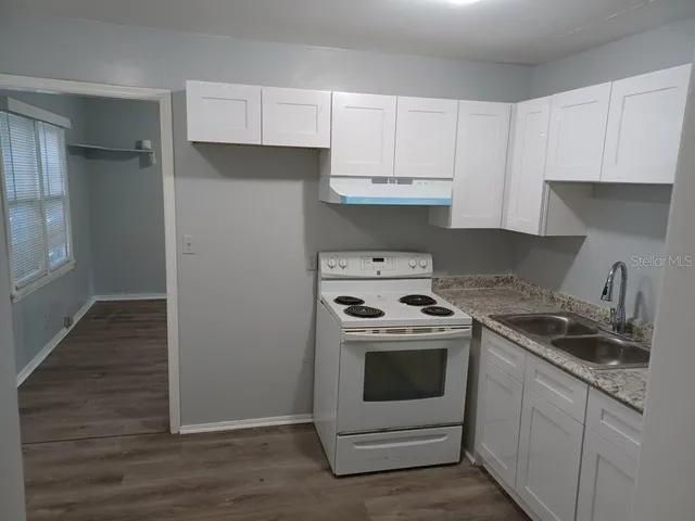 a kitchen with a stove top oven and cabinets