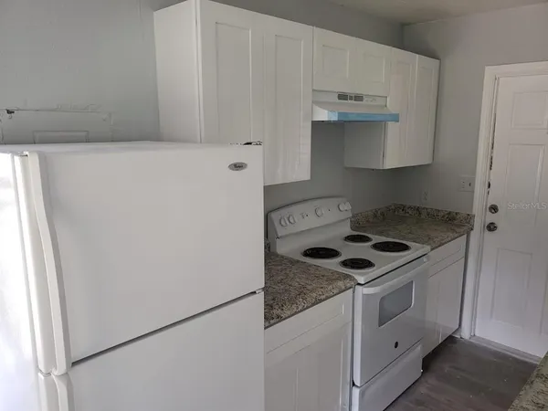 a kitchen with granite countertop cabinets and white stove