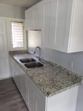 a kitchen with stainless steel appliances granite countertop a sink stove and cabinets