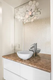 a bathroom with a granite countertop sink a mirror and shower