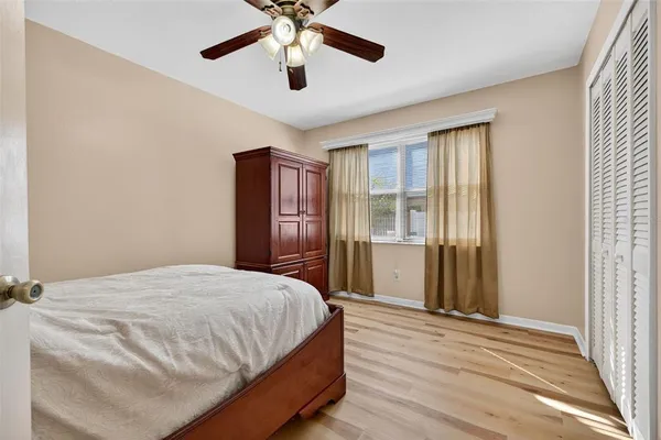 a bedroom with a bed and a large window with wooden floor