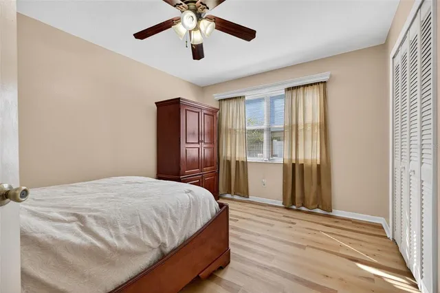 a bedroom with a bed and a large window with wooden floor