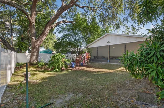 a view of a house with a yard and large trees