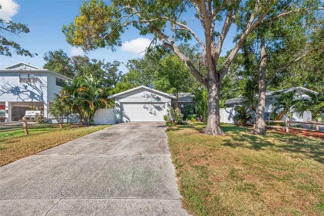 a front view of a house with a yard and trees