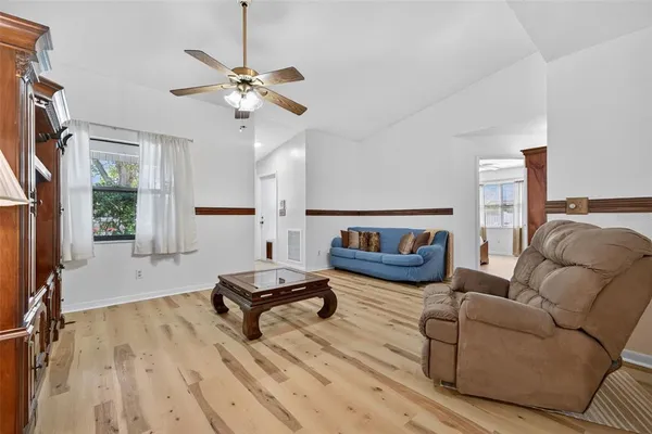 a living room with furniture and a wooden floor