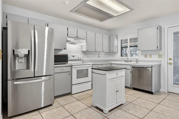 a kitchen with white cabinets stainless steel appliances and sink