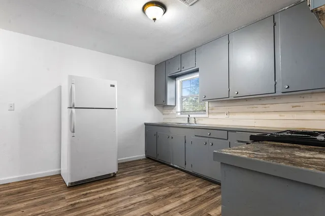 a kitchen with a refrigerator and a stove top oven