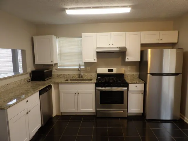a kitchen with a sink stove and refrigerator