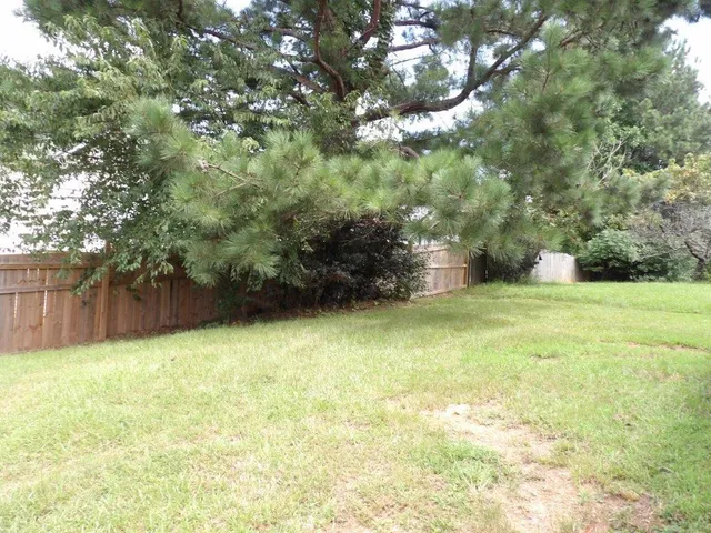 a view of yard with swimming pool and green space