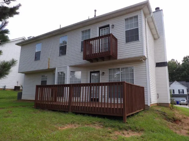 a view of a house with a yard and deck