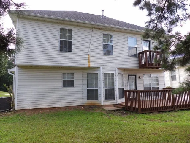 a view of a house with a yard and deck