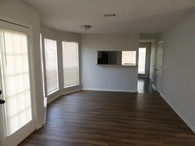 a view of a livingroom with wooden floor and a window