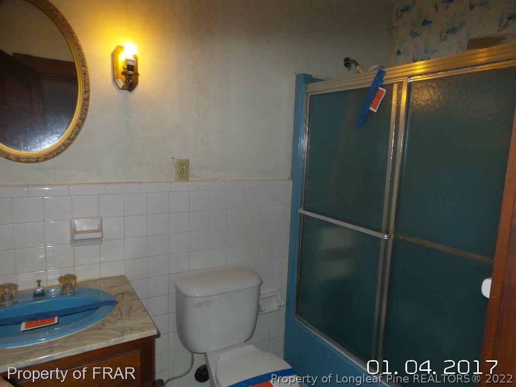 5141 Rockingham Road Laurel Hill, NC 28351 - Photo 13 of 14 a bathroom with a toilet and a mirror