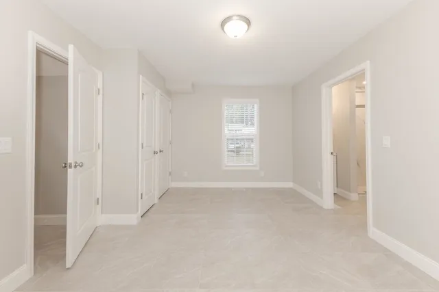 a bathroom with a toilet a sink a mirror a shower a vanity and window