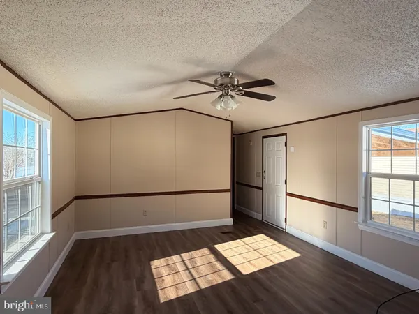 a view of a bedroom with wooden floor and a window