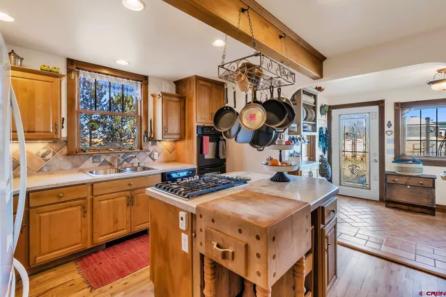 a kitchen with stainless steel appliances a stove a sink dishwasher and cabinets with wooden floor